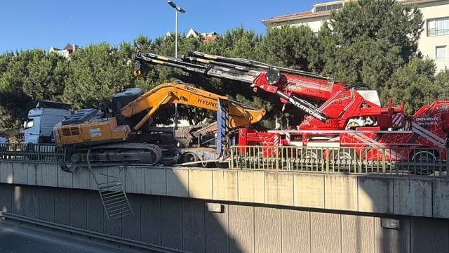 Tırdan düşen ekskavatör alt geçidin korkuluklarında asılı kaldı